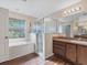 Bright bathroom with a shower, tub, and vanity with solid-surface countertop at 10247 Mason Loop, Clermont, FL 34711