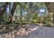 Paver patio bordered with lush, tropical foliage and mature trees creating a private and serene outdoor retreat at 107 Wayland Cir, Longwood, FL 32779