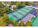 Aerial view featuring neighborhood tennis courts with benches, well-maintained greenery, and lighting at 107 Wayland Cir, Longwood, FL 32779