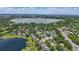 Aerial view of a lake community with homes, boat docks, lily pads, and a large lake at 1113 Hawthorne Cove Dr, Ocoee, FL 34761