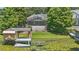 Back of house with screen porch, view of backyard, dock with boat lift, and lake with lily pads at 1113 Hawthorne Cove Dr, Ocoee, FL 34761