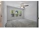 Bedroom featuring neutral toned walls, carpeted floors, a ceiling fan, and large windows at 1113 Hawthorne Cove Dr, Ocoee, FL 34761