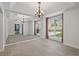 Bright dining room with large mirror, neutral walls, a chandelier, and large windows letting in natural light at 1113 Hawthorne Cove Dr, Ocoee, FL 34761