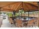 Outdoor kitchen and bar features seating, TV, ceiling fan, grill, sink and view of the lake and boat dock at 1113 Hawthorne Cove Dr, Ocoee, FL 34761