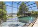 Screened in pool area featuring two swimming pools, a hot tub, and scenic lake views at 1113 Hawthorne Cove Dr, Ocoee, FL 34761