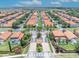 Aerial view of community entrance with lush landscaping, tile roofs, and screened pools at 112 Cordova Ave, Davenport, FL 33897