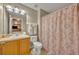 Cozy bathroom with a vanity, toilet, and shower featuring a patterned curtain and decorative towels at 112 Cordova Ave, Davenport, FL 33897