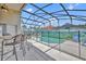 Entertaining screened-in outdoor bar overlooking the pool, perfect for socializing and enjoying refreshments by the water at 112 Cordova Ave, Davenport, FL 33897
