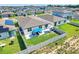 Aerial view of landscaped yard, outdoor seating, new home, solar panels and surrounding neighborhood at 1127 Foreshore Ln, Haines City, FL 33844