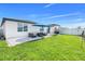 The backyard features a well-manicured lawn, outdoor seating area, and a stylish patio, perfect for relaxing or entertaining at 1127 Foreshore Ln, Haines City, FL 33844