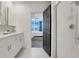 Bright bathroom with a double sink vanity and a glass door shower and view to bedroom at 1127 Foreshore Ln, Haines City, FL 33844