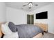 A well-lit bedroom with a ceiling fan, TV, modern furniture, and neutral color palette at 1127 Foreshore Ln, Haines City, FL 33844