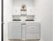 Clean laundry area with a washer, dryer, and overhead storage cabinets at 1127 Foreshore Ln, Haines City, FL 33844