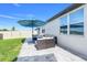 Inviting outdoor patio with stylish furniture, umbrella, and views of the grassy backyard and white privacy fence at 1127 Foreshore Ln, Haines City, FL 33844