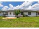 A home's backyard featuring a small patio, lawn, and minimalist landscaping at 11811 Scarecrow Ln, Orlando, FL 32821