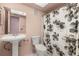 Cozy bathroom with a pedestal sink and floral shower curtain adding a touch of nature at 11811 Scarecrow Ln, Orlando, FL 32821