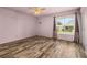 Bright bedroom featuring a window with natural light and wooden-look flooring, offering a comfortable retreat at 11811 Scarecrow Ln, Orlando, FL 32821