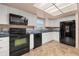 Well-lit kitchen featuring white cabinets, black appliances, and tiled backsplash at 11811 Scarecrow Ln, Orlando, FL 32821