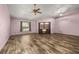 Bright, expansive living room featuring wood laminate flooring and a ceiling fan at 11811 Scarecrow Ln, Orlando, FL 32821