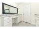 Bathroom vanity featuring white cabinets, gray granite countertops, large mirror and exterior door at 1204 Duncan Ct, Longwood, FL 32779