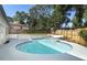 Backyard pool with a blue tiled edge, surrounded by landscaping and a wooden fence at 1204 Duncan Ct, Longwood, FL 32779