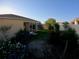 Backyard with tropical landscaping and screen-enclosed patio at 1221 Santa Cruz Dr, The Villages, FL 32162