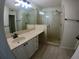 Bright bathroom featuring a glass-enclosed shower and vanity with storage at 1221 Santa Cruz Dr, The Villages, FL 32162