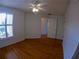 Inviting bedroom with wood floors, ceiling fan, bright window, and white trim at 1221 Santa Cruz Dr, The Villages, FL 32162