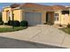 Charming single-story home with tan exterior, landscaped front yard, and well-lit driveway at 1221 Santa Cruz Dr, The Villages, FL 32162