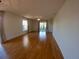 Open living room with gleaming hardwood floors, neutral walls, and modern light fixtures at 1221 Santa Cruz Dr, The Villages, FL 32162