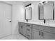 Modern bathroom featuring a double vanity with gray cabinetry and marble floors at 13525 Se 100Th Ave, Belleview, FL 34420