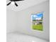 A sunlit bedroom with a large window overlooking an expansive yard and neighboring home at 13525 Se 100Th Ave, Belleview, FL 34420