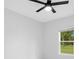 Bright bedroom features a ceiling fan and a large window with view of the trees at 13525 Se 100Th Ave, Belleview, FL 34420