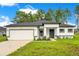 Charming single-story home featuring a two-car garage, modern design, and well-manicured lawn at 13525 Se 100Th Ave, Belleview, FL 34420