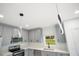 Modern kitchen with gray cabinetry, stainless steel appliances, and quartz countertops at 13525 Se 100Th Ave, Belleview, FL 34420