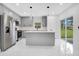 Modern kitchen features gray cabinets, center island, and stainless steel appliances, creating a stylish cooking space at 13525 Se 100Th Ave, Belleview, FL 34420