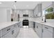 Modern kitchen with gray cabinets, white quartz countertops, and stainless steel appliances at 13525 Se 100Th Ave, Belleview, FL 34420