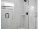 Modern shower showcasing marble tiling, a built-in shelf, and a sleek matte black fixture at 13525 Se 100Th Ave, Belleview, FL 34420