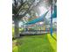 Community playground with swings and a slide, under a shade, surrounded by green grass at 14033 Turning Leaf Dr, Orlando, FL 32828