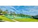 Well-lit tennis court surrounded by lush landscaping, providing a scenic and active recreational space at 14033 Turning Leaf Dr, Orlando, FL 32828