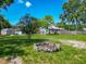 A large backyard with a fire pit and additional sheds, set against a backdrop of a beautiful blue sky at 141 S Central Ave, Apopka, FL 32703