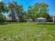 Expansive green backyard features multiple sheds and a partial view of the home's exterior at 141 S Central Ave, Apopka, FL 32703