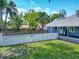Fenced backyard featuring a well-maintained lawn and mature palm trees offering shade and privacy at 141 S Central Ave, Apopka, FL 32703