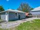 Exterior shot of a home with a gravel driveway, lawnmower parking, and green yard for outdoor activities at 141 S Central Ave, Apopka, FL 32703