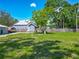 Exterior view of backyard with a shed, house, car port and expansive green lawn for outdoor enjoyment at 141 S Central Ave, Apopka, FL 32703