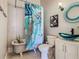Bathroom featuring a clawfoot tub with artistic shower curtain, blue glass sink, and patterned decorative mirror at 141 S Central Ave, Apopka, FL 32703
