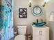 Bathroom featuring a glass sink, modern fixtures, a round decorative mirror, and artistic sconces at 141 S Central Ave, Apopka, FL 32703