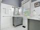 Bright bathroom featuring a gray vanity with marble countertop, and a window providing natural light at 141 S Central Ave, Apopka, FL 32703