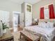 Bright main bedroom with red curtains, a plush rug, a neutral color scheme, wood flooring, and attached bathroom at 141 S Central Ave, Apopka, FL 32703