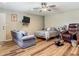 Comfortable bedroom showcasing a ceiling fan, television, loveseat, and chair for relaxation and convenience at 141 S Central Ave, Apopka, FL 32703